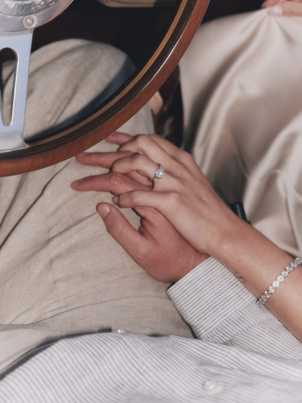Holding hands on the steering wheel, engagement ring